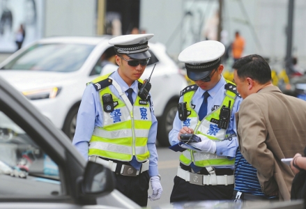 5月3日，成都市北打金街路口，交警三分局民警对一位开车打手机的驾驶员进行处罚。